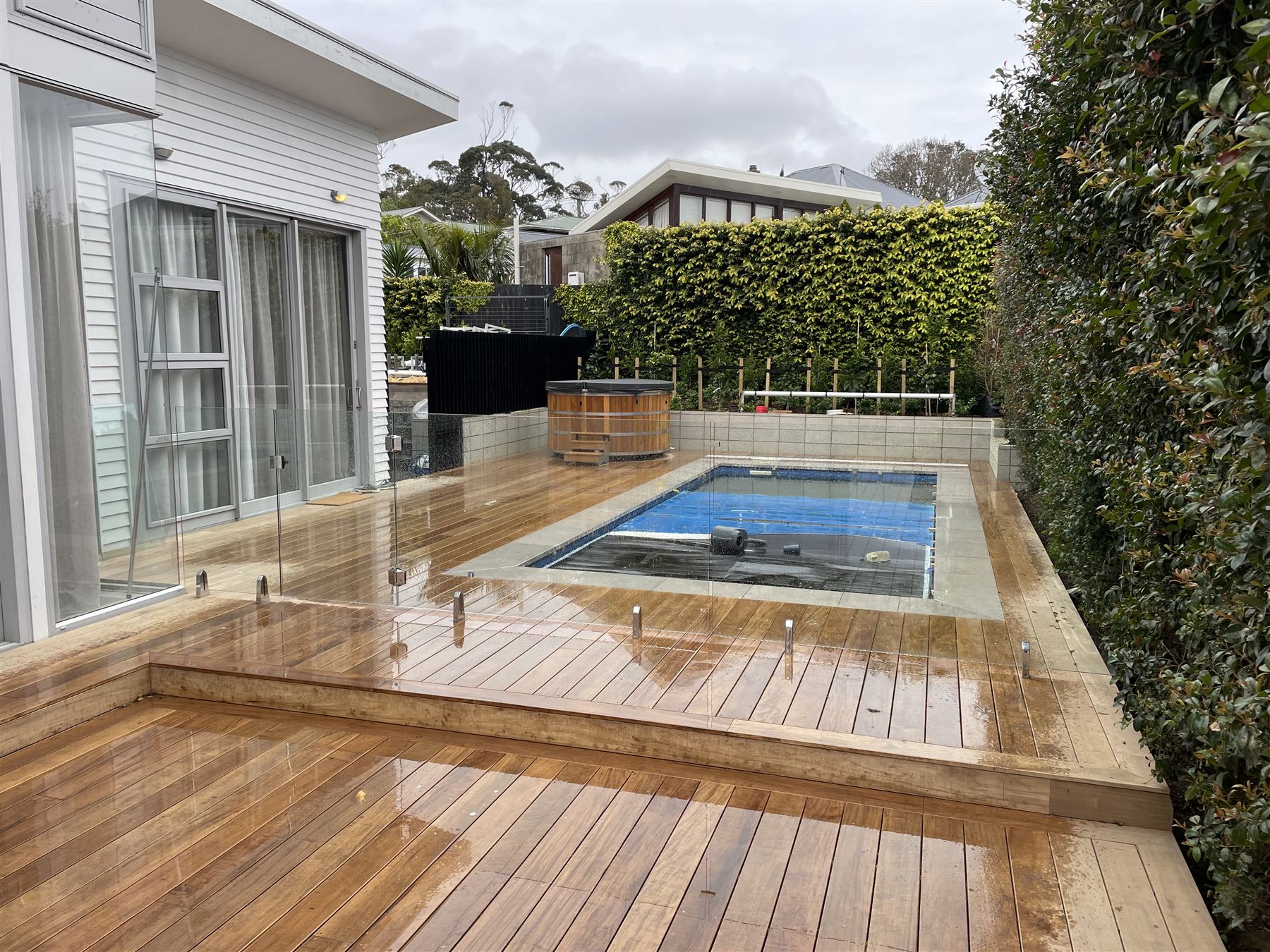 Timber deck with glass fencing around a residential pool